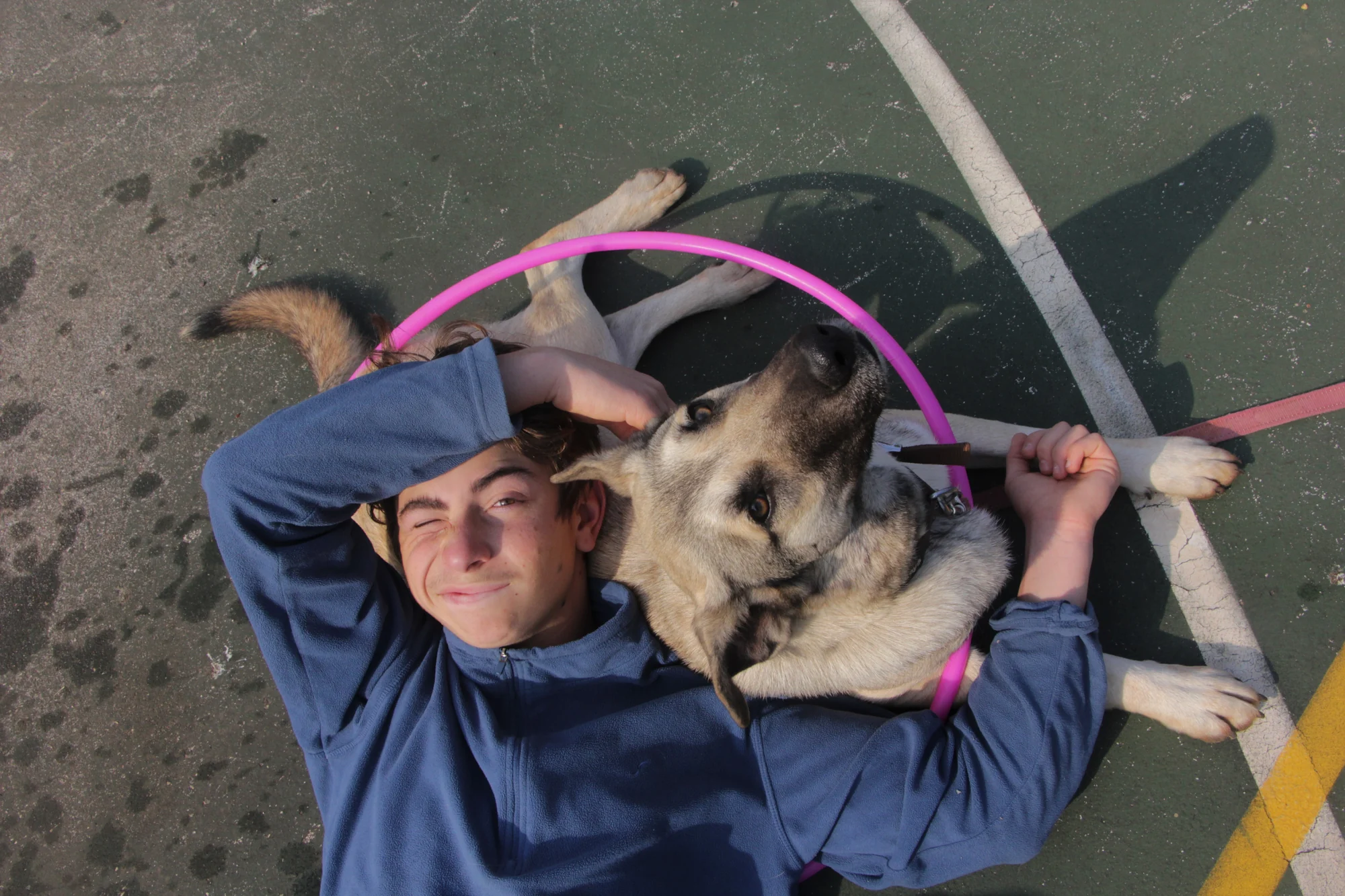 A young person and a dog resting side by side at Eshbal